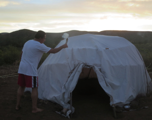 The spiritual healer purifies the temazcal hut with sage smoke prior to our beginning the traditional sweat lodge experience..