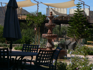 A welcoming courtyard with the elevated private dining area of Fuego behind it at Hotel Boutique.